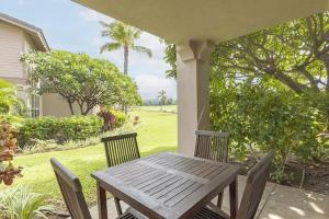 a wooden table and chairs on a porch at Summer Special! Hilton Pool Pass included! in Waikoloa