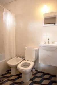 a white bathroom with a toilet and a sink at Lapacho Amarillo, departamento turístico Salta in Salta