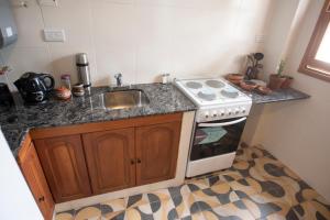 a kitchen with a stove and a sink at Lapacho Amarillo, departamento turístico Salta in Salta