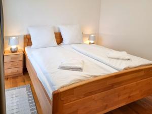 a large bed with white sheets and pillows on it at Villa Friede-Marie - App Finja Hafen-Ostsee-Blick in Sassnitz