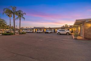 un estacionamiento con autos estacionados frente a un motel en Plainsman Motel en Forbes