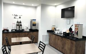 a restaurant with a counter and a table and chairs at Americas Best Value Inn & Suites Kingwood IAH Airport in Kingwood