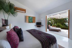 ein Schlafzimmer mit einem Bett, einem Sofa und einem Fenster in der Unterkunft Casa Aries in Costa Careyes