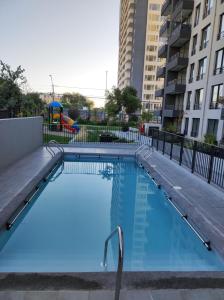 una piscina vacía en un edificio de apartamentos en Departamento arriendo diario, en Santiago