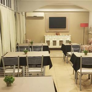 uma sala de jantar com mesas e cadeiras e uma televisão de ecrã plano em Hotel Azul Junin em Junín