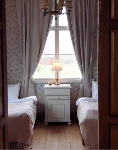 1 Schlafzimmer mit 2 Einzelbetten und einem Fenster in der Unterkunft Ronehamn Bed and Breakfast in Hemse