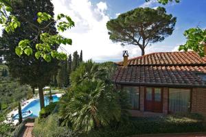 a house with a swimming pool next to a resort at Borgo Bucciano in San Miniato