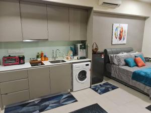 cocina pequeña con lavadora y cama en Avenpeak Homestay Tamarind Wifi, Netflix, Iron, Filter, TV, Self Checkin en Cyberjaya