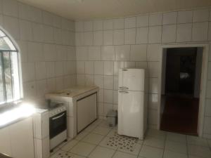 a white kitchen with a refrigerator and a stove at Hospedagem com carinho! in Curitiba