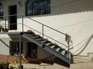 a man riding a skateboard down a metal staircase at Hospedagem com carinho! in Curitiba