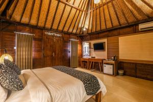 a bedroom with a bed and a television in a room at The Kleep Jungle Resort in Nusa Penida