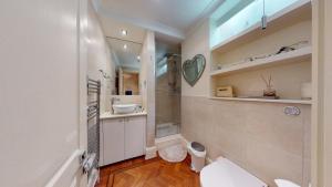 a bathroom with a toilet and a shower and a sink at The Hayes Place Lodge in London