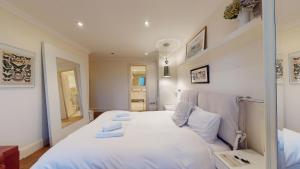 a bedroom with a bed with white sheets and pillows at The Hayes Place Lodge in London