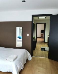 a bedroom with a white bed and a hallway at Hermosa Habitación con balcon cama mat y litera Polanco in Mexico City