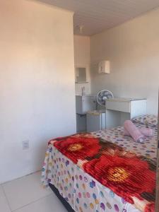 a bedroom with a bed with a colorful blanket at Hospedaria da Cris in Salvador