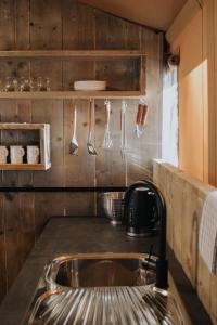 una cucina con lavandino e utensili appesi al muro di Koondrook Glamping Retreat a Koondrook