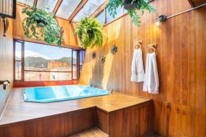 Habitaciones en un alojamiento -Anfitrion - Elias Di Caprio في بوغوتا: حمام مع حوض استحمام أزرق ونافذة