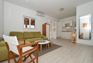 a living room with a couch and a table at Apartments by the sea Seget Vranjica, Trogir - 1037 in Seget Vranjica