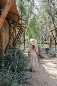 a girl in a hat walking down a dirt path at Koondrook Glamping Retreat in Koondrook