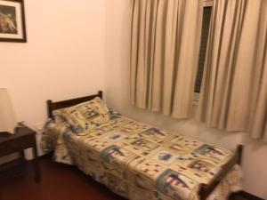 um quarto com uma cama e uma janela em bungalow hotel dollar em Punta del Este