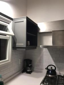 uma cozinha com armários pretos e uma chaleira no fogão em bungalow hotel dollar em Punta del Este