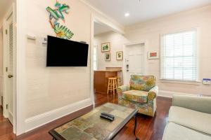 a living room with a flat screen tv on the wall at Palm Gardens in Key West