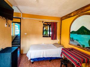 a bedroom with a bed and a painting on the wall at Casa Argentina in San Juan La Laguna