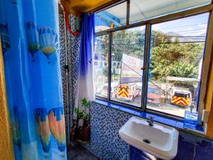 a bathroom with a sink and a large window at Casa Argentina in San Juan La Laguna