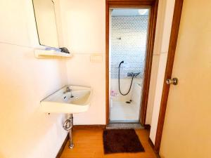 a bathroom with a sink and a shower at Weekly Hotel Kokura in Kitakyushu