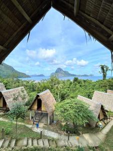 a group of huts with a view of the ocean at Forest Camp El Nido in El Nido