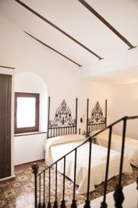 a bedroom with a large bed and a large window at Hostal Palacio del Corregidor in Córdoba