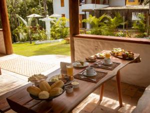 a table with plates of food on top of it at Villa Sagui Trancoso in Trancoso