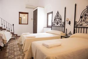 a group of four beds in a room at Hostal Palacio del Corregidor in Córdoba