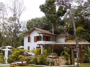 a white house with tables and chairs in front of it at Villa Sagui Trancoso in Trancoso