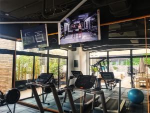 Tijax 10 apartamento en zona 10 في غواتيمالا: صالة ألعاب رياضية مع العديد من آلات المشي وتلفزيون بشاشة مسطحة