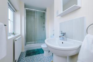 a white bathroom with a sink and a toilet at 3 Bedroom! 3 Toilets! Contractors and Groups! Free Parking! Driveway! NEW BUILD HOUSE! in Burton upon Trent