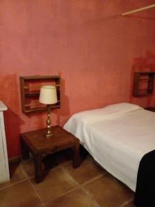 1 dormitorio con 1 cama y 1 mesa con lámpara en Dormi en Mar del Plata! en Mar del Plata