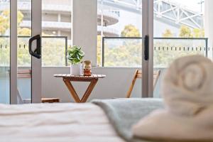 a person laying on a bed in a room with windows at Commodious 2 Bedroom APT in OP in Sydney