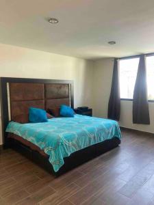 a bedroom with a bed with blue sheets and blue pillows at PRECIOSA CASA NUEVA UNA PLANTA NAMASTE in Tlaxcala de Xicohténcatl