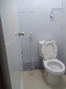 a bathroom with a white toilet and a shower at Lojed Sean bed and space in Manila