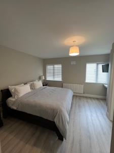 a bedroom with a large bed and a lamp at No. 8 Ceide Spris Self Catering House in Killarney