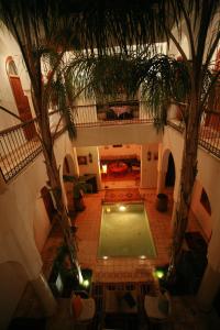 einen Blick über den Pool in einem Gebäude mit Palmen in der Unterkunft Riad Mariana in Marrakesch