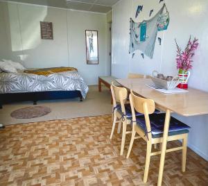 um quarto com uma mesa e cadeiras e uma cama em Waihi Beach B&B em Waihi Beach