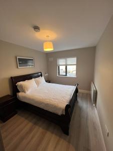 a bedroom with a bed and a window and a light at No. 8 Ceide Spris Self Catering House in Killarney