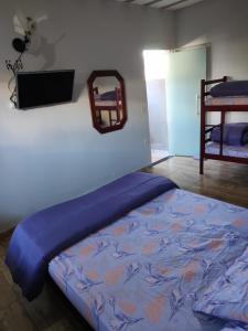 een slaapkamer met een bed met een blauw dekbed bij Kitnet em Cabo Frio 02 in Cabo Frio
