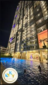 un gran edificio con una piscina frente a él en 1BR Condo Unit at Celandine Condominium Near Ayala Cloverleaf Mall en Manila