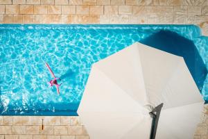 un buzo en una piscina con sombrilla en BIG4 Opal Holiday Park, en Lightning Ridge