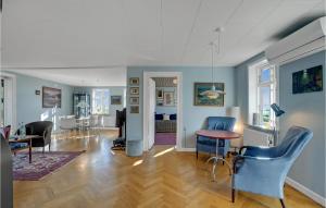 - un salon avec des chaises bleues et une table dans l'établissement 5 Bedroom Awesome Home In Erslev, à Erslev