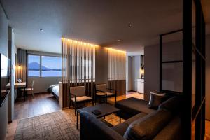 a living room with a couch and a room with a bed at The Lake View Toya Nonokaze Resort in Lake Toya