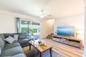 a living room with a couch and a flat screen tv at 110 Catalina Close so close to the water in Shoal Bay